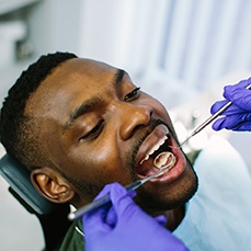 Dentist examining patient's teeth at dental checkup