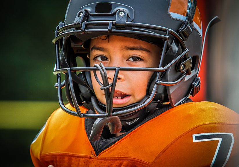 Close-up of little boy in football uniform