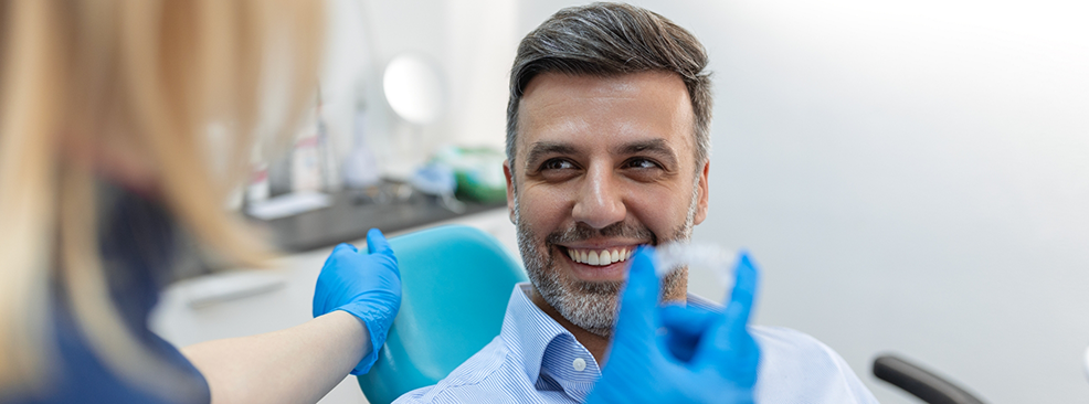 Dentist showing patient a clear aligner in Pantego