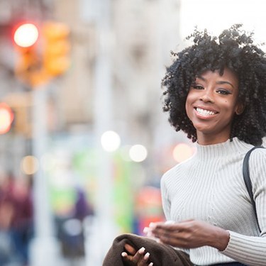 Young woman smiling and walking in the city