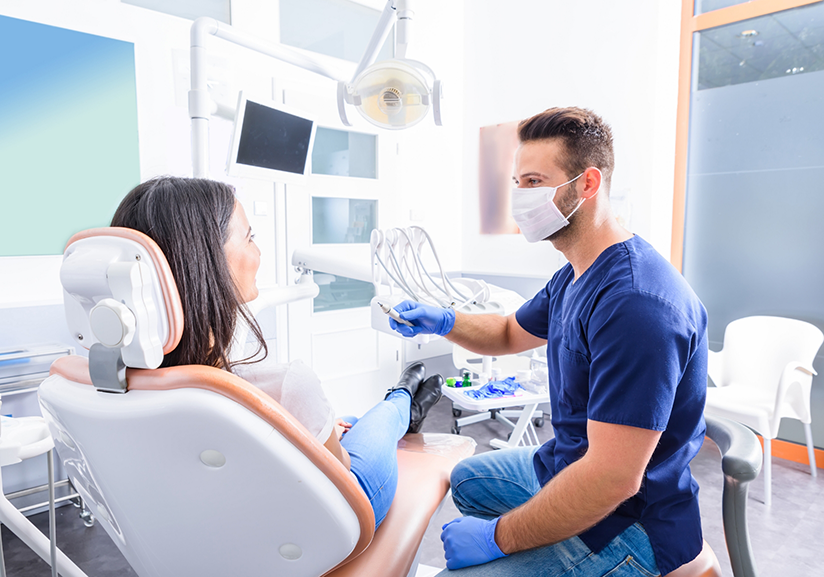 Male dentist sitting next to female patient