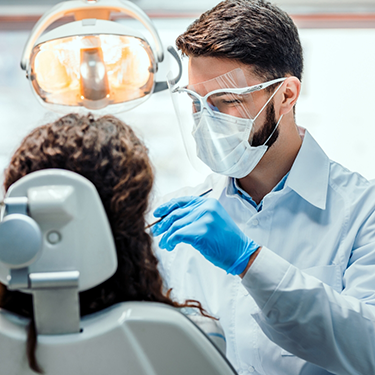 Male dentist treating patient