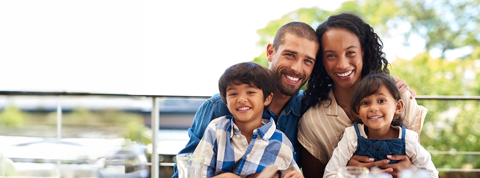 Family huddled together outside and smiling