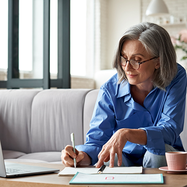 Woman sitting on couch filling out paperwork