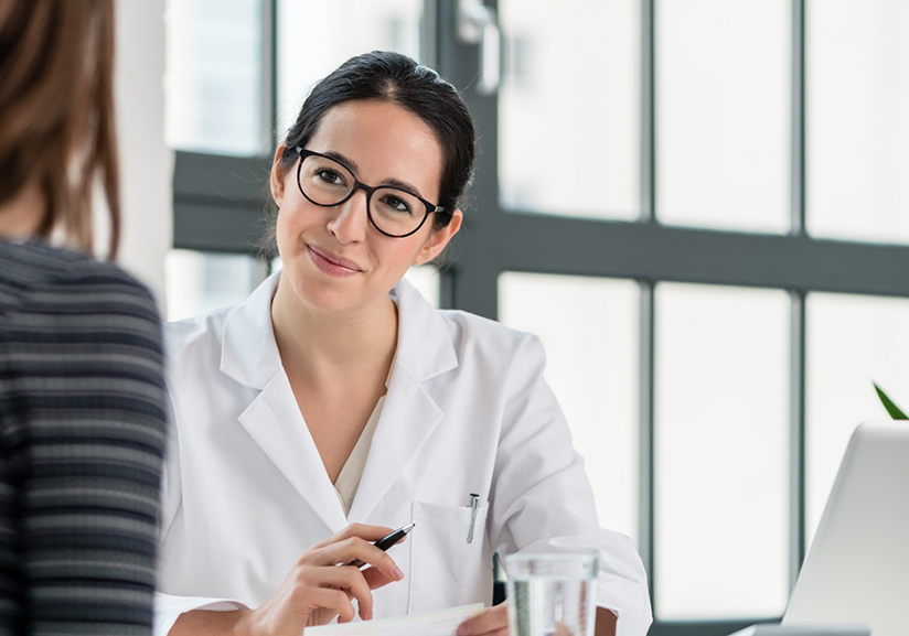 Dentist with glasses sitting in front of computer