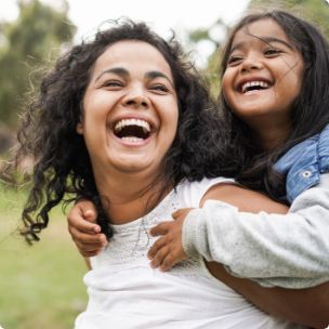 Woman giving little girl a piggyback ride