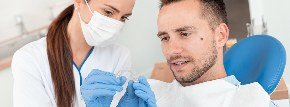 Dentist showing male patient a clear aligner