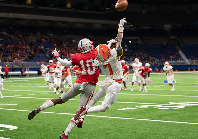 Two football players lunging for ball