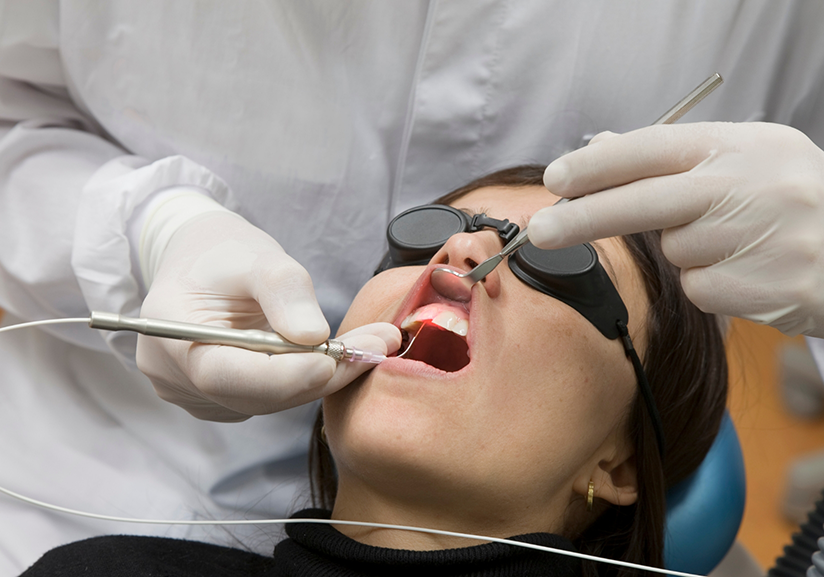 Female patient having gums treated with dental laser