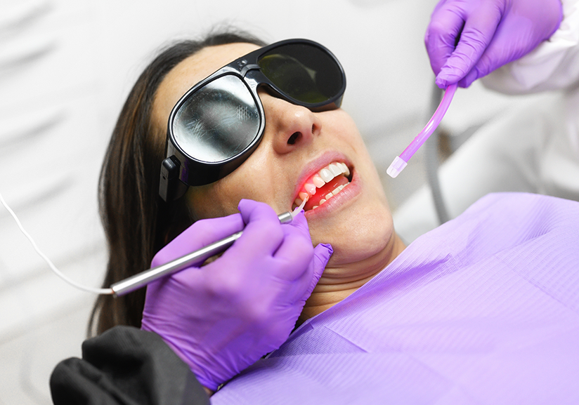 Woman with protective sunglasses receiving laser dentistry