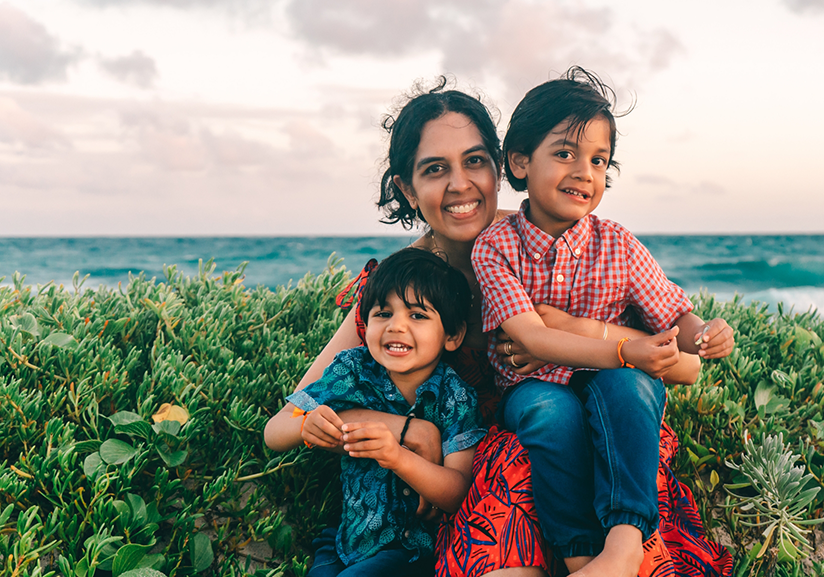 Dr. Shah sitting in grass with her kids