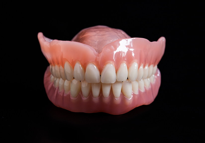 Close-up of full dentures on black background