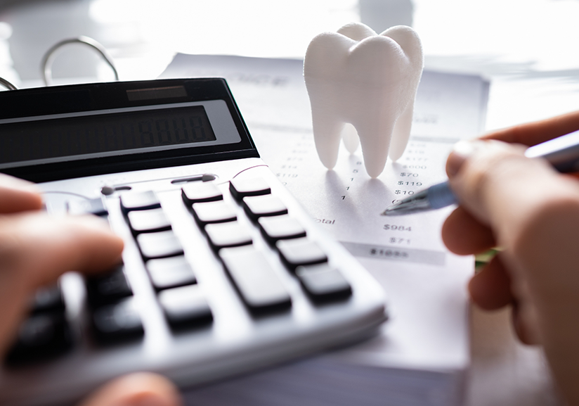 Using calculator and filling out paperwork under tooth paperweight