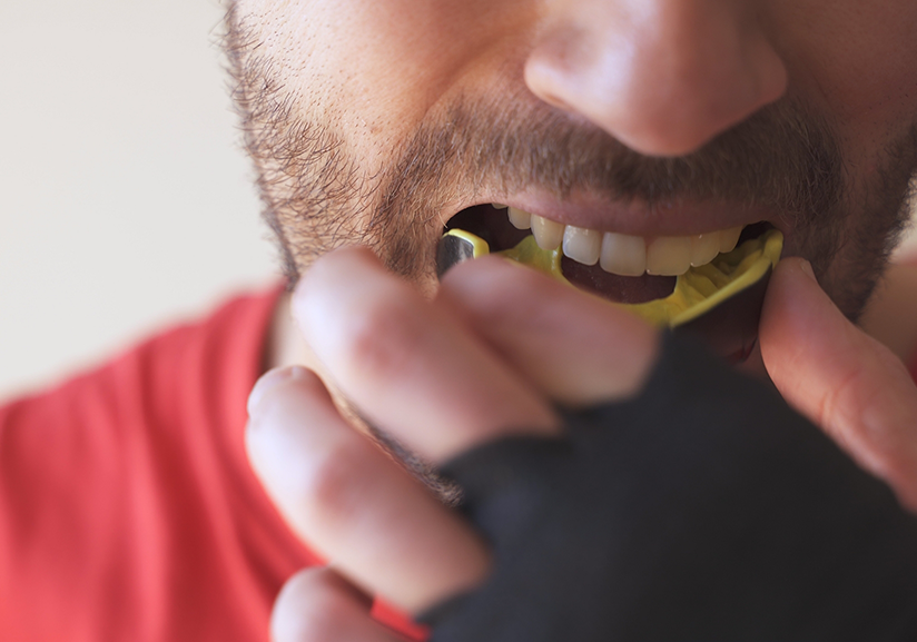 Close up of man putting in athletic mouthguard