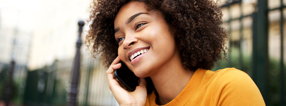 Woman in yellow shirt talking on her phone