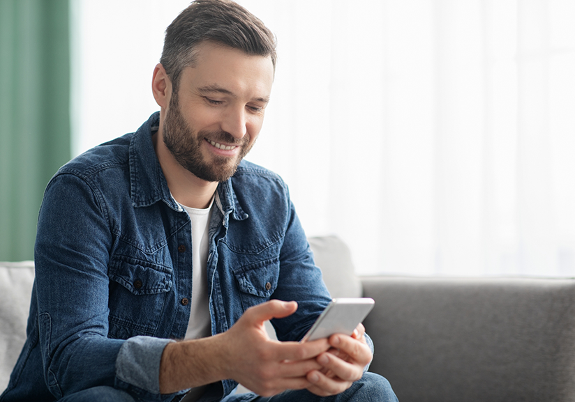 Man sitting on couch looking at phone