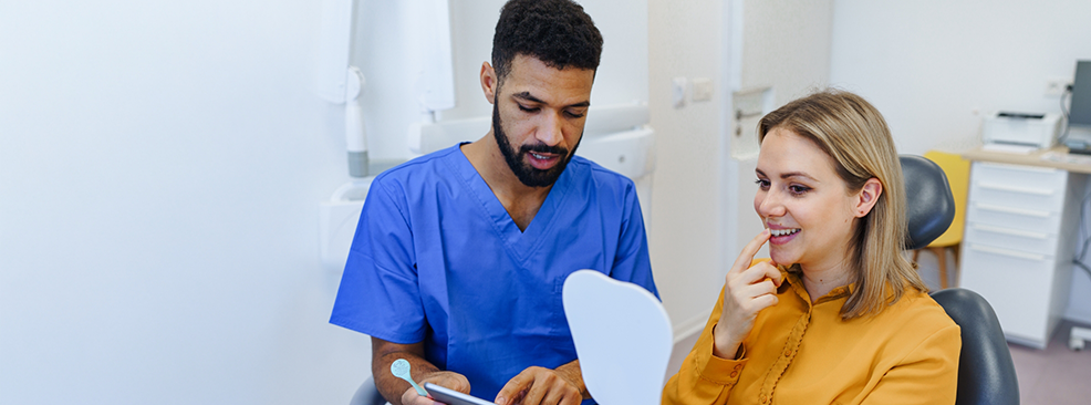 Dentist in blue shirt and patient in yellow shirt