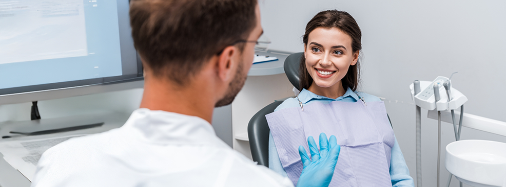 Back shot of dentist talking to patient